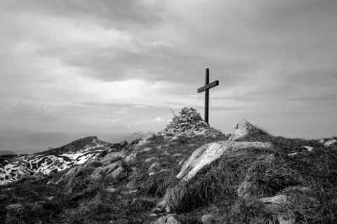 La croix du sommet de la Grande Sure, en noir et blanc, avec les crêtes derrière