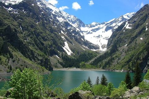 Le lac Lauvitel aux eaux vertes, encaissé entre les versants boisés et les sommets enneigés