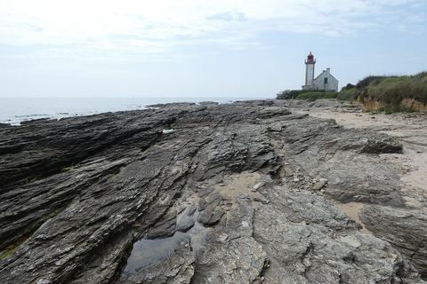 Les dalles de schiste de la pointe des Chats et le phare au fond