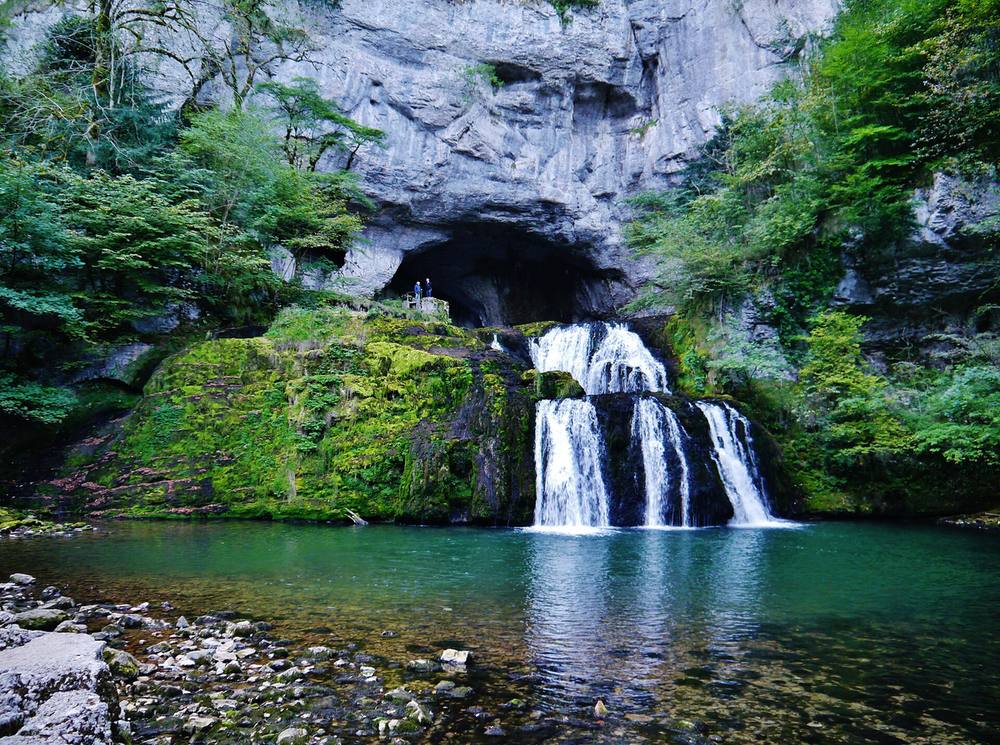 La source du Lison jaillissant de sa grotte au-dessus d'une vasque verte