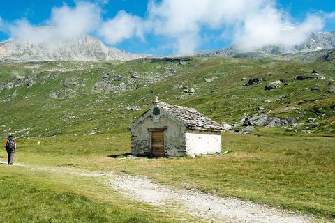 La chapelle du Fond d'Aussois sur le plateau d'alpage, avec un randonneur sur le sentier